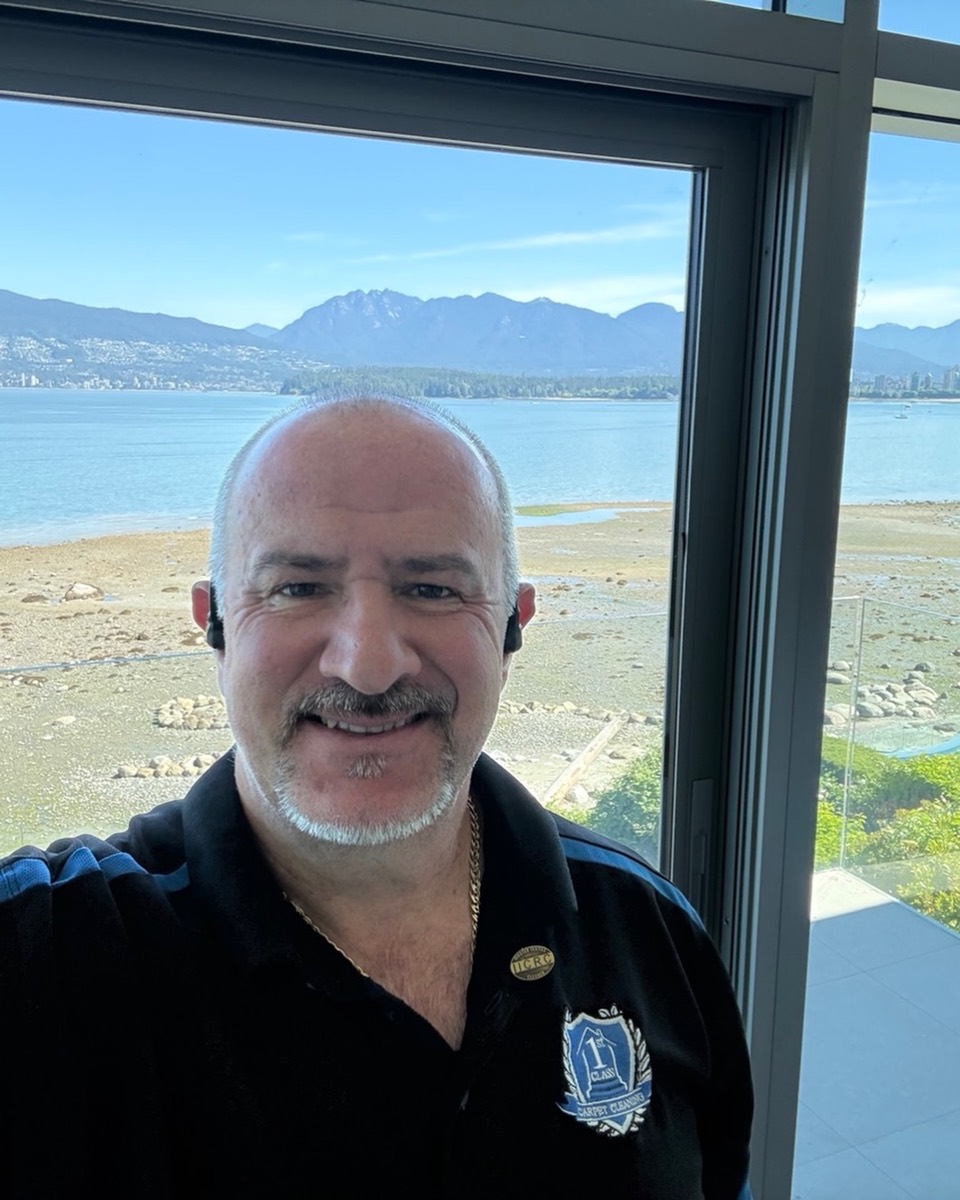 Harry from First Class Carpet Cleaning, IICRC certified, with a Vancouver ocean and mountain backdrop