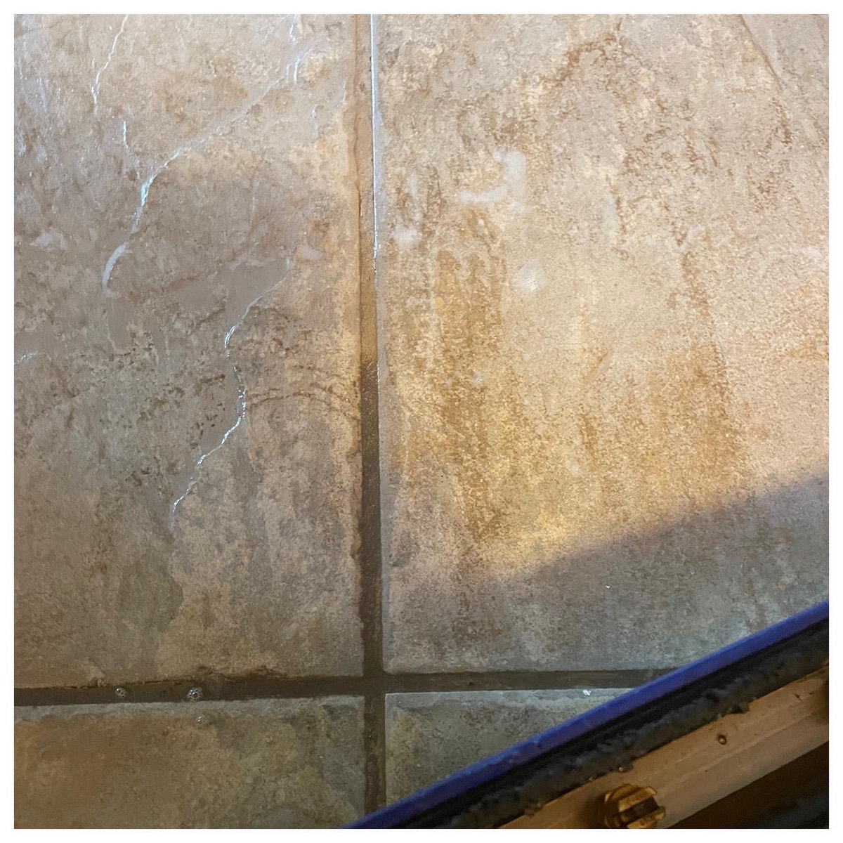 Travertine tile floor showing glossy clean versus soiled sections during cleaning in Vancouver